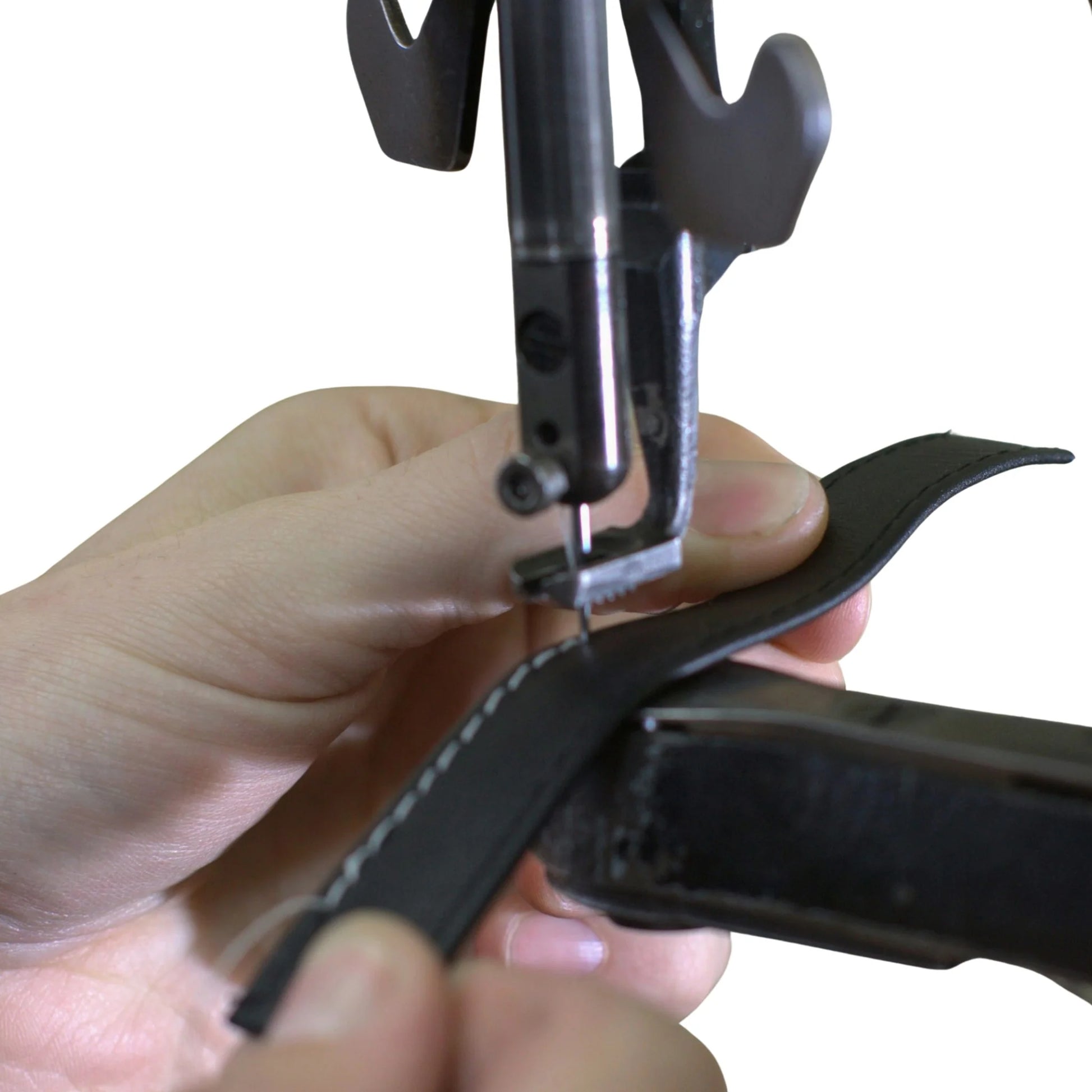 Hand using a leather edge crimper on a white background