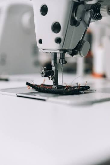 Close-up of a sewing machine needle in action with a blurred background