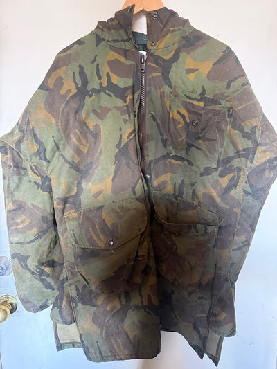 Camouflage jacket on a hanger against a white wall