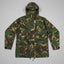 A hooded camouflage jacket in green, brown, and tan tones, laid flat against a neutral gray background.