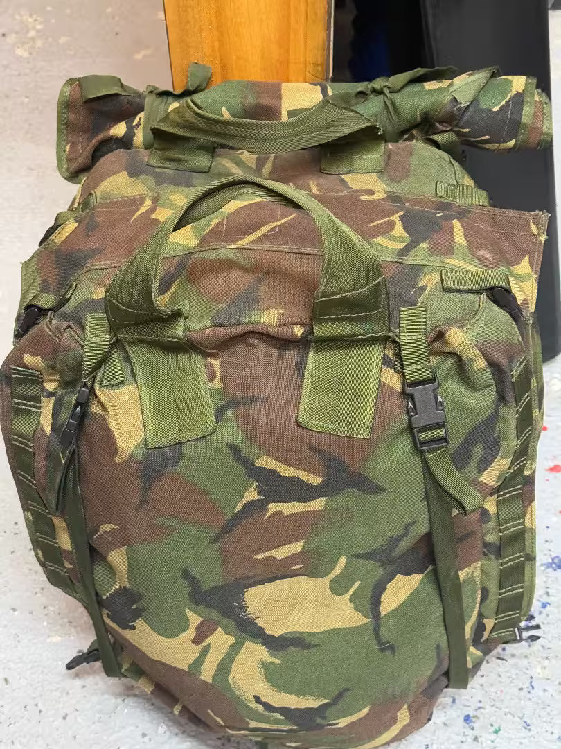 Camouflage backpack on a light gray surface