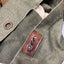 Close-up of a green fabric with leather patch and metal button