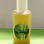 Bottle of 'Heart Of The Forest' product on a green surface with a neutral background