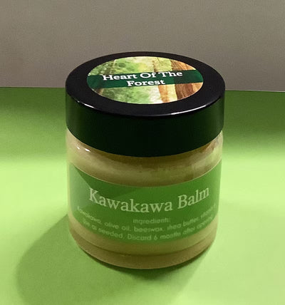 Jar of Kawakawa Balm with a green label on a green surface