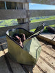 Green bag with leather items on a wooden surface with a mountainous background