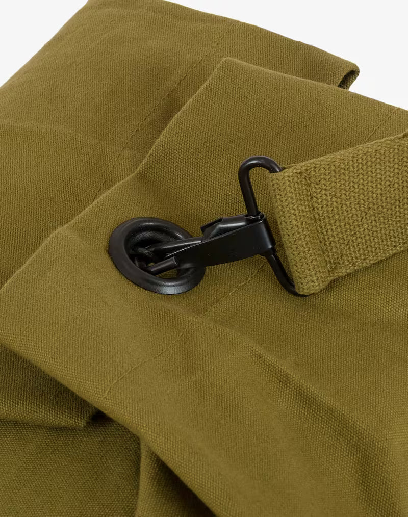Close-up of a green fabric with a black buckle and strap on a white background