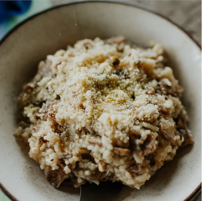 Close-up of a bowl with a scoop of rice pudding on a wooden table.