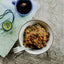 Bowl of food with a cup of tea and map on a wooden surface