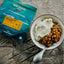 Back Country Cuisine meal package with a bowl of food on a wooden surface