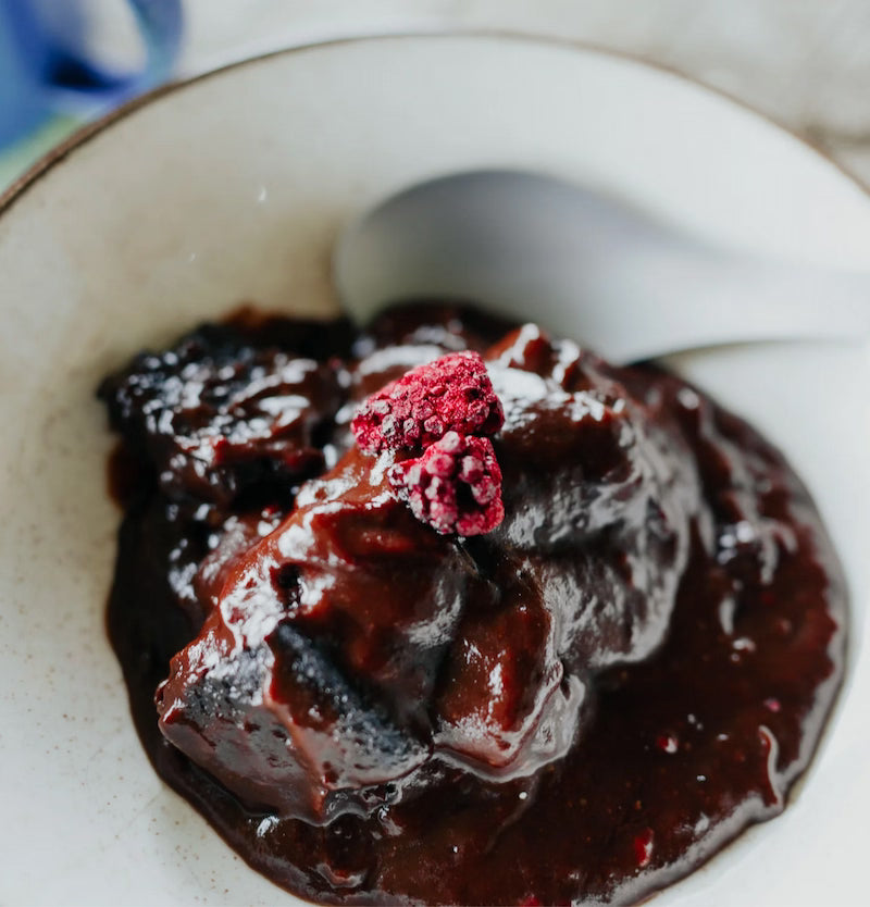 Chocolate dessert with a raspberry on a white plate