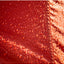 Close-up of a red surface with water droplets and a textured brown background.