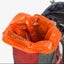 Orange trash bag inside a backpack with visible Klean Kanteen branding.