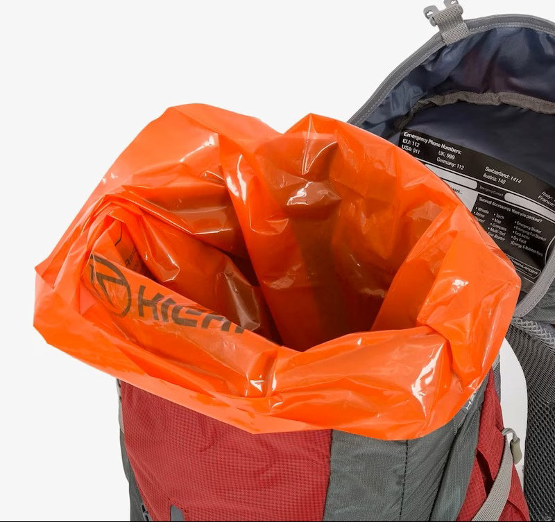 Orange trash bag inside a backpack with visible Klean Kanteen branding.