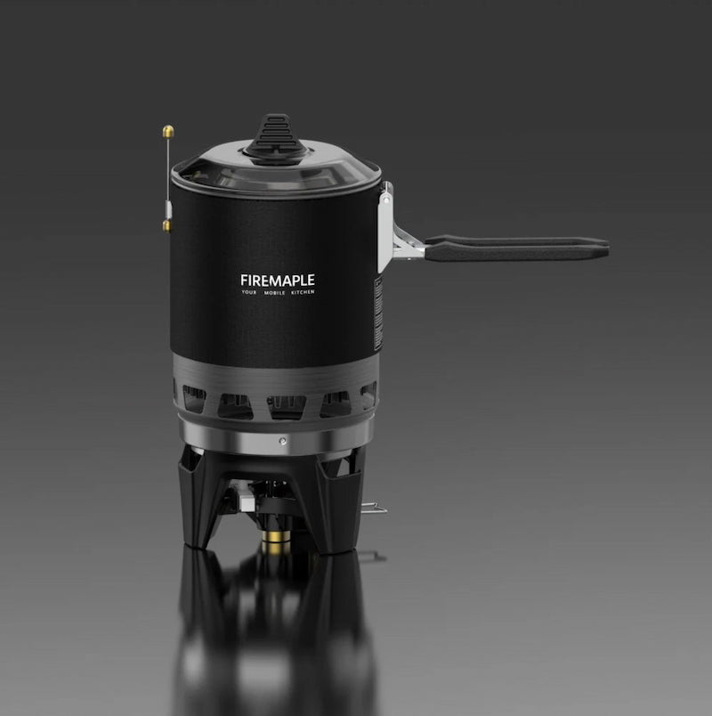 Black camping stove with visible Firemaple branding on a gray background