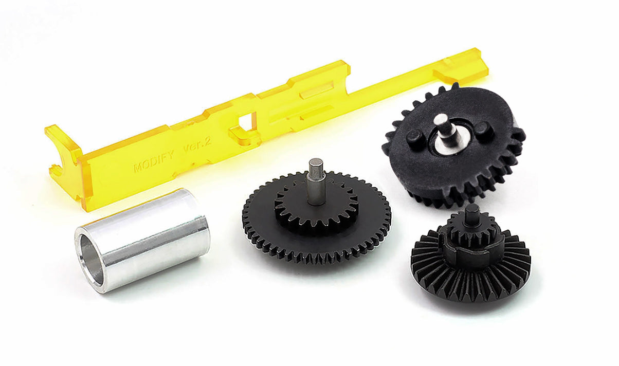 Mechanical components including gears and a yellow plastic bracket on a white background