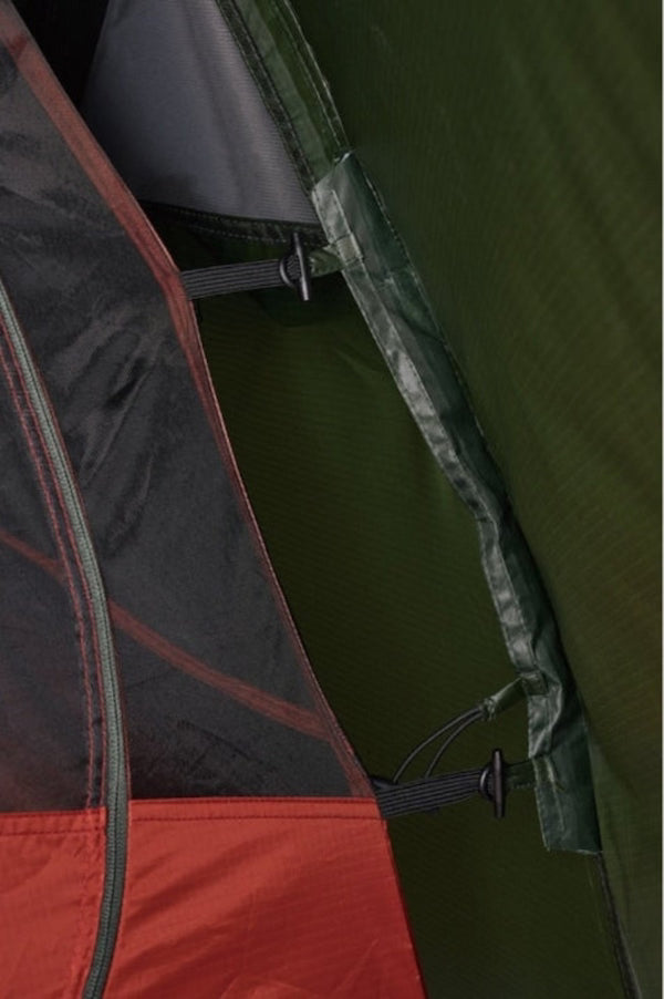 Close-up of a tent with red, black, and green sections.