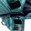Close-up of a teal jacket with black patches and a zipper
