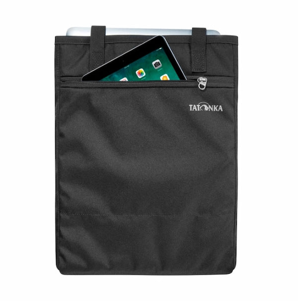 A black Tatonka tablet sleeve with a front zippered pocket containing a tablet, shown against a plain white background.