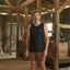 Man standing in a rustic wooden interior space with beams and wooden furniture.