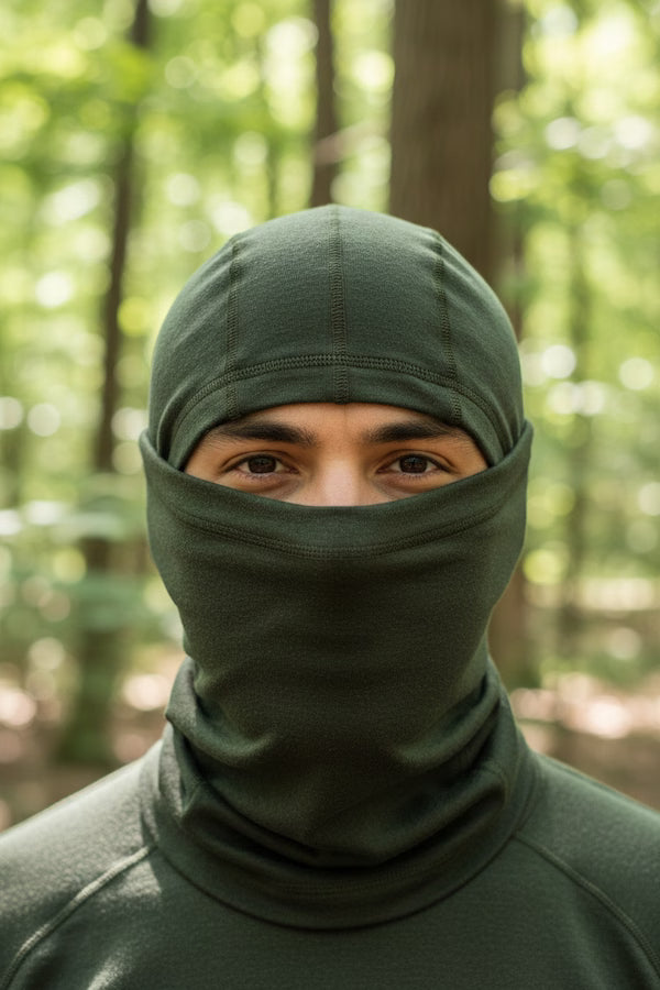 Person wearing a green balaclava in a forest setting