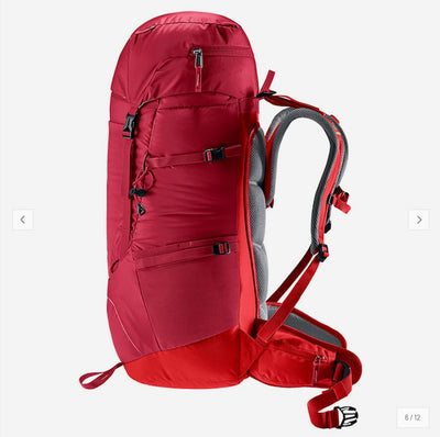 A red hiking backpack with gray padded shoulder straps and side buckles, shown from the side on a light gray background.