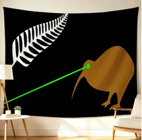 A black wall tapestry featuring a white silver fern and a brown kiwi bird design, shown hanging in a room setting with a lamp, side table, and chair.