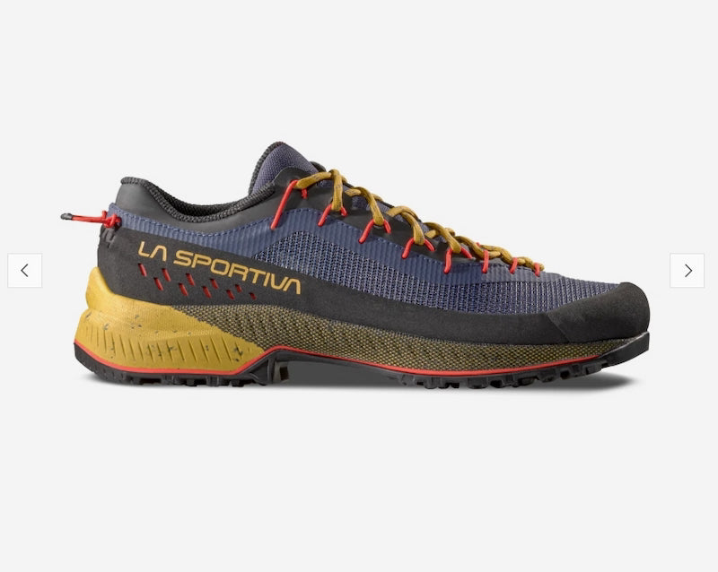 A La Sportiva trail running shoe in navy blue and black with mustard yellow laces, a yellow midsole, and red accents, shown against a light gray background.