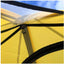 Close-up of a yellow tent with black straps against a blue sky.