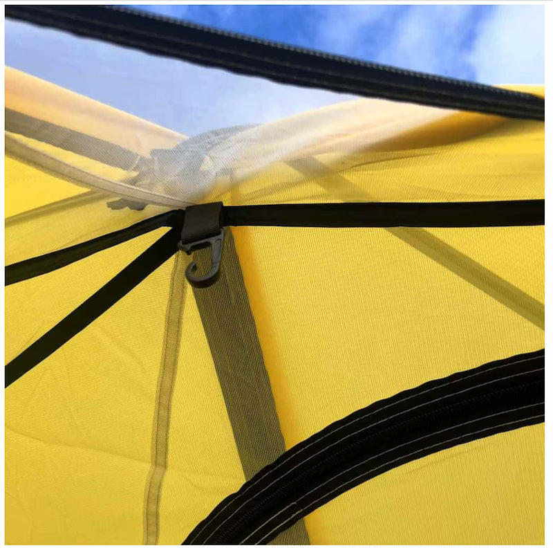Close-up of a yellow tent with black straps against a blue sky.