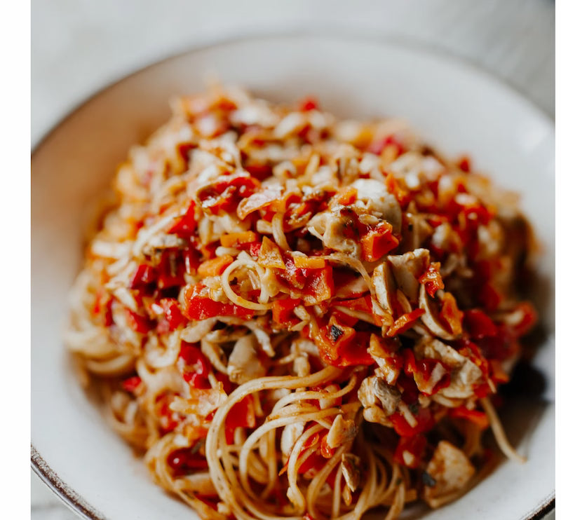 Spaghetti dish with red sauce and meat on a white plate