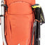 Orange hiking backpack with attached climbing tools on a white background