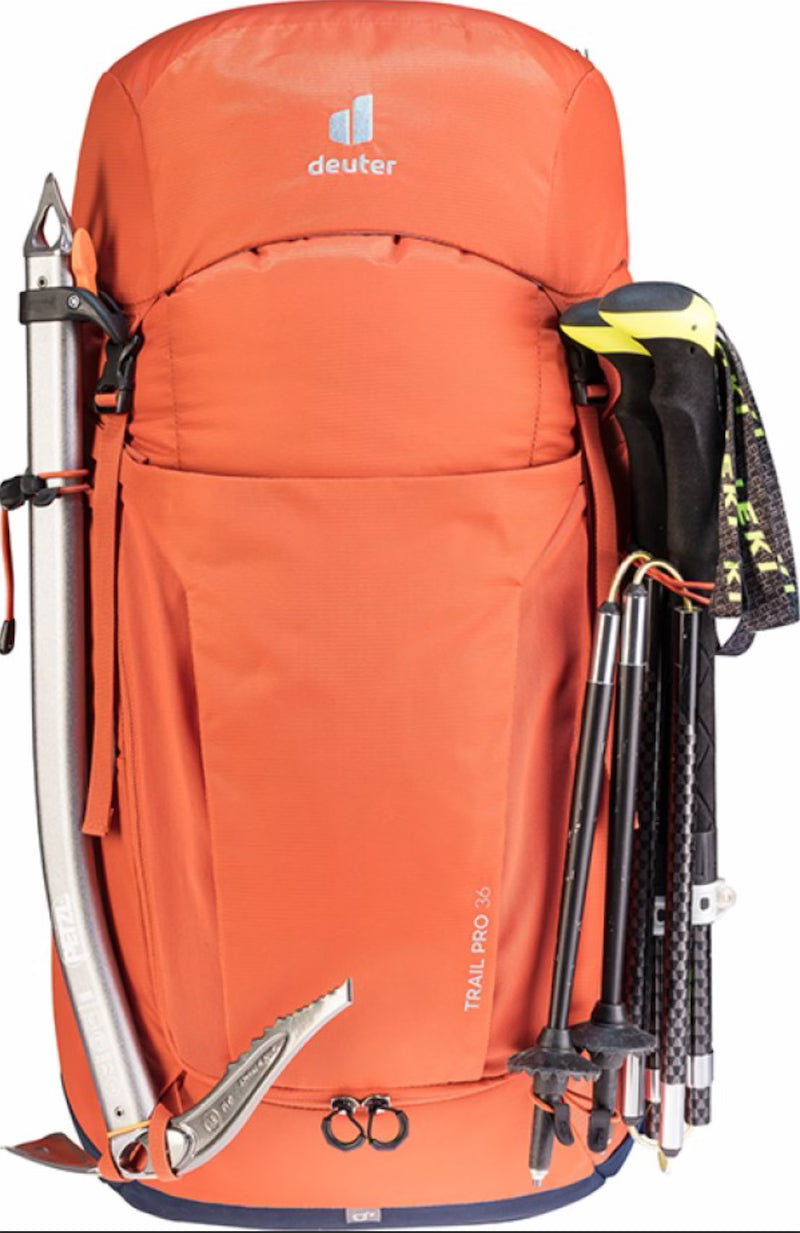 Orange hiking backpack with attached climbing tools on a white background