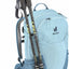 Light blue hiking backpack with trekking poles on a white background