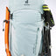 Light blue hiking backpack with attached ski poles and a ski on a white background