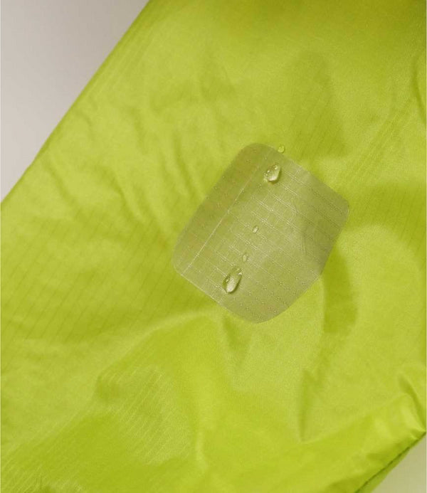 Green fabric with water droplets demonstrating water resistance.