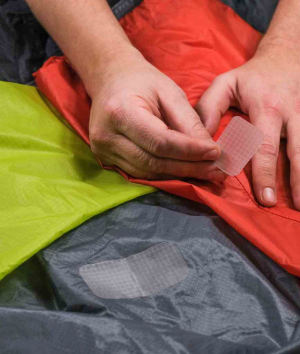 Person applying a patch to a piece of fabric with another patch already attached.
