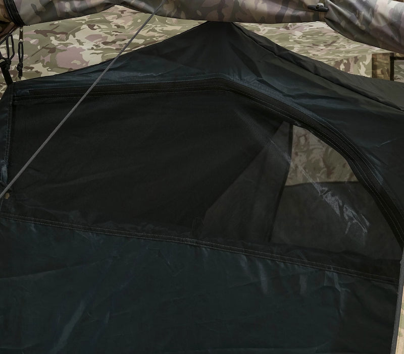 Close-up of a black tent flap with camouflage patterned fabric in the background
