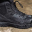 Black tactical boot with a rugged sole on a wet surface