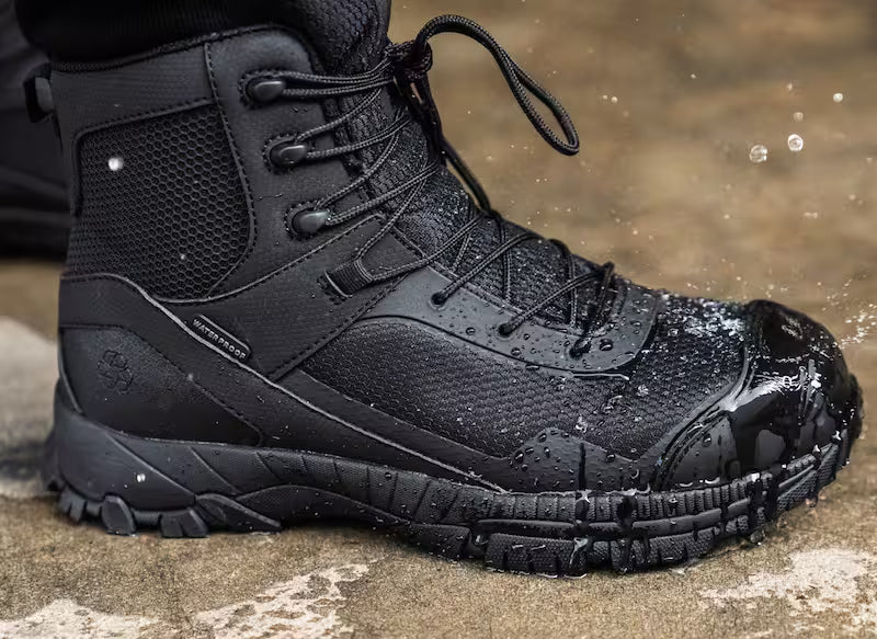 Black tactical boot with a rugged sole on a wet surface