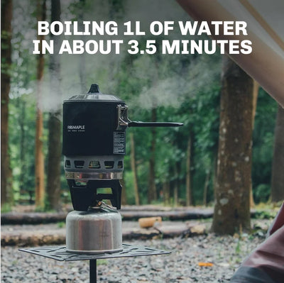 Portable stove with a kettle boiling water outdoors, surrounded by trees.
