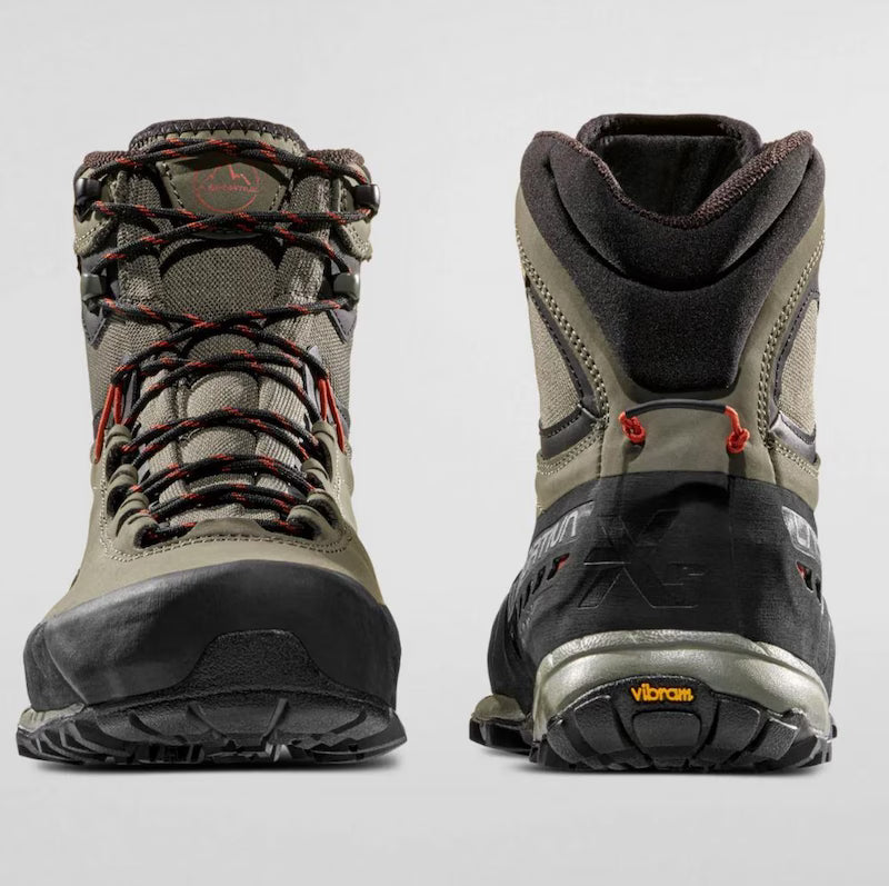 Pair of hiking boots with visible brand logos on a light gray background