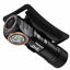 A black tactical flashlight with a detachable black clip, featuring a copper-colored bezel around the lens and white branding text that reads 'FENIX' and 'M23 PRO'.