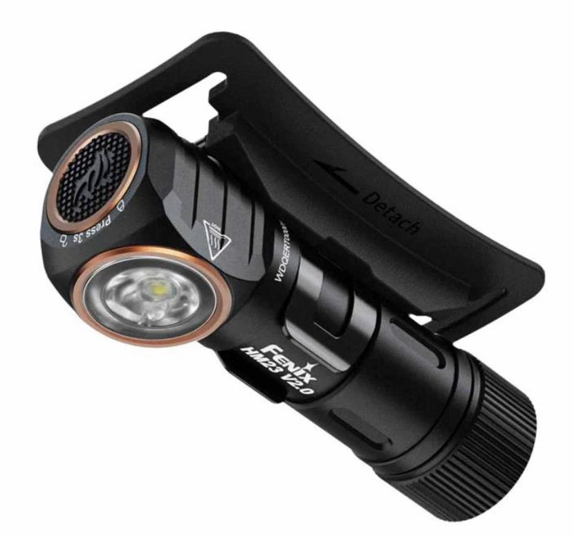 A black tactical flashlight with a detachable black clip, featuring a copper-colored bezel around the lens and white branding text that reads 'FENIX' and 'M23 PRO'.