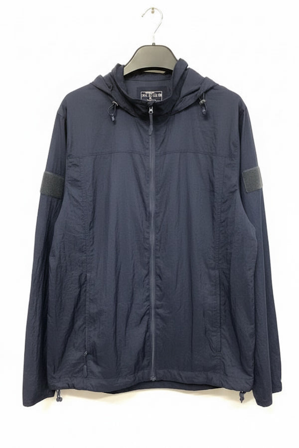 A dark navy hooded lightweight jacket hanging on a black hanger against a plain white background. The jacket features a full-length front zipper, a drawstring hood, zippered hand pockets, and dark gray sleeve patches.