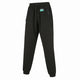 Black fleece jogger pants with an elastic drawstring waist, zippered side pockets, and a small green and white logo patch on the left hip.