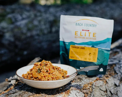 Back Country Elite backpacking food package with a bowl of food on a natural background