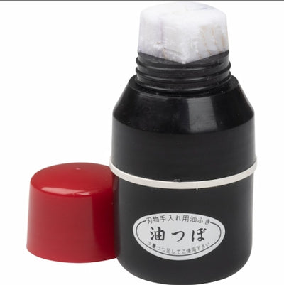 Black ink bottle with red cap on a white background