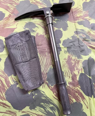 Metal folding shovel with black sheath on camouflage-patterned surface