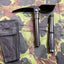 Two tools, one with a pouch, on a camouflage-patterned surface