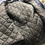 Gray quilted jacket on a hanger with a blurred background